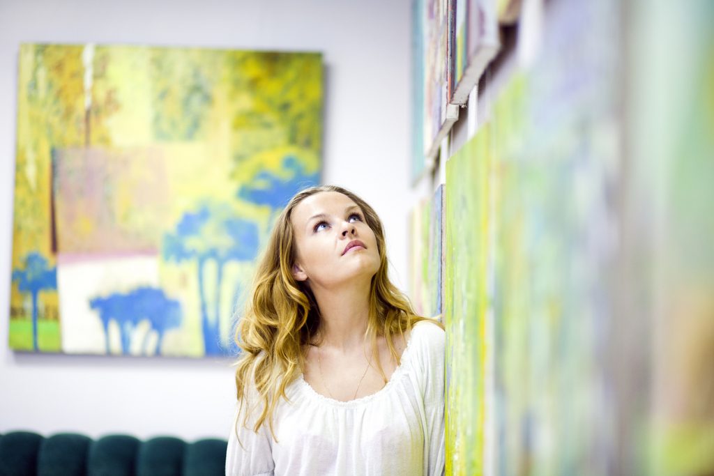 Artistic woman gazing at artwork on the wall