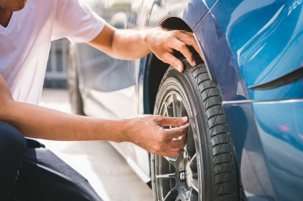 technician removing tire valve cap for tire inflation service