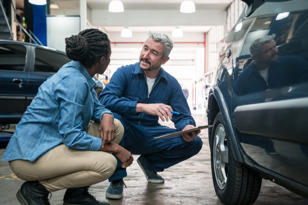 Car mechanic talking with customer